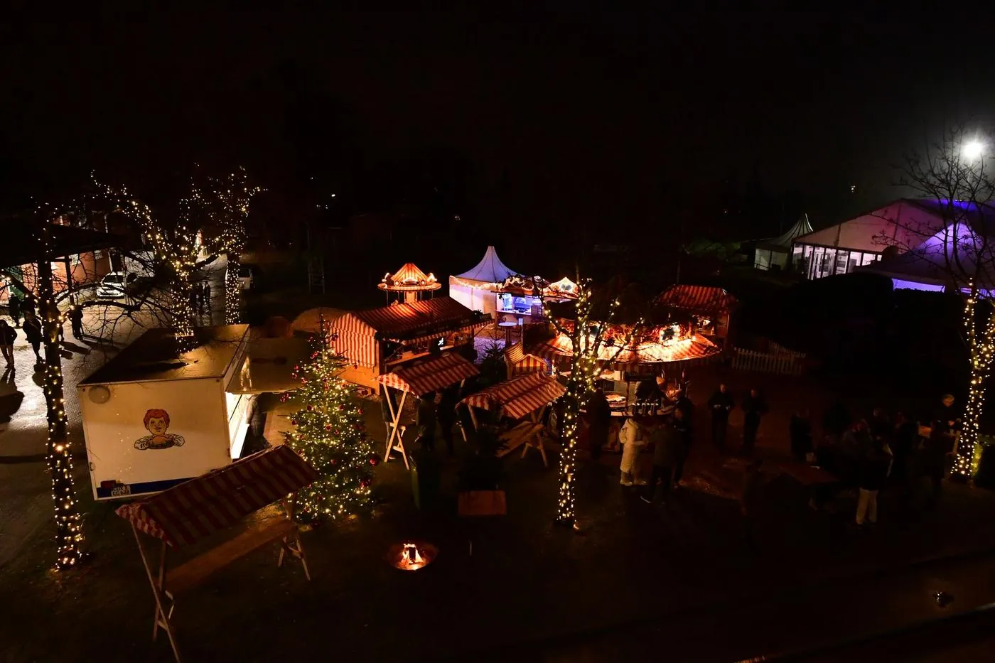 Wintermarkt auf dem Vorplatz mit Hüttendorf, Karussell, Feuerschale und Lichterketten